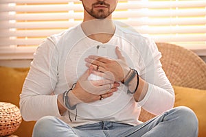 Young man during self-healing session in room, closeup