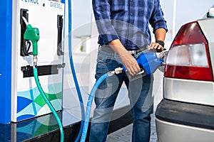young man self refueling car at petrol or gas filling station after paying from mobile - concept of transportation