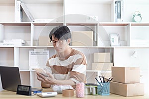 Young man selling products online was chat on the phone to receive an order from a customer and wrote down the list in a notebook