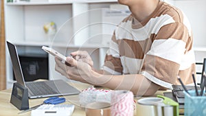 Young man selling products online was chat on the phone to receive an order from a customer and wrote down the list in a notebook