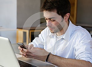 Young man sending text message on mobile phone