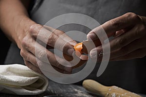 Young man separating the yolk of an egg