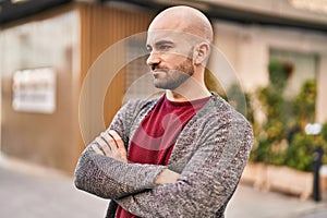 Young man with serious expression and arms crossed gesture at street