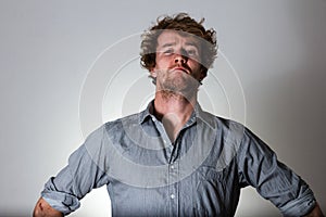 Young man serious judgemental on gray background photo