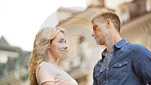 Young man seriously looking at girlfriend, woman late for date, apologetic look