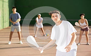 Young man serving ball during Basque pelota game outdoors photo