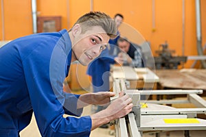 Young man setting up equipment in woodwork class