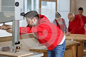 Young man setting up woodworking machine