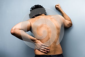 Young man with severe back pain from sciatica photo