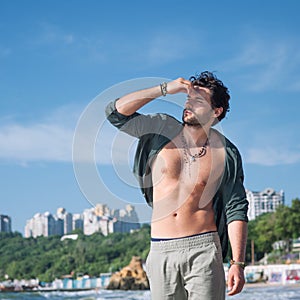Young man sexy topless outdoor portrait near the ocean