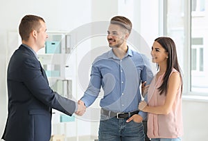 Young man shaking hands with estate agent in office