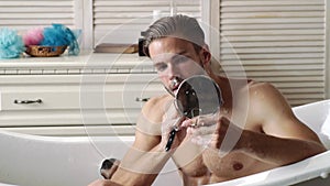 Young man shaving face near mirror in bathroom. Male beauty, beard care skincare concept.