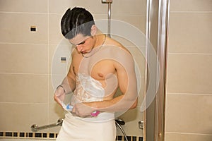 Young man shaving hair from stomach and chest