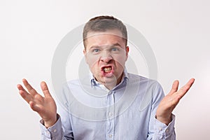 Young man in shirt in anger shouts and threatens