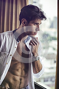 young man with shirt open on muscular chest