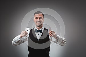 Young man in shirt and waistcoat shows his poker cards, studio shot