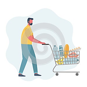 Young man with shopping cart full of food and drinks