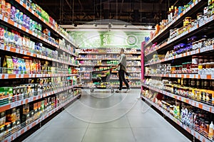 young man with shopping cart between store shelf