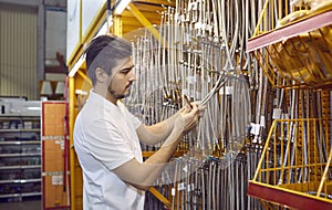 Young man shopping at a DIY store and trying to choose a new stainless steel hose