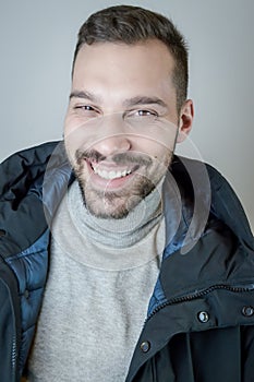 Young man with a short beard laughs cheerfully during a conversation