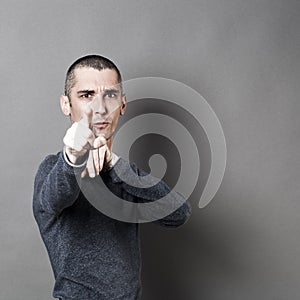 Young man with short hair accusing or denouncing someone