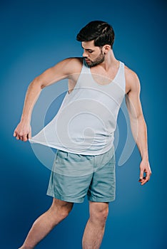 young man in shorts looking at white singlet