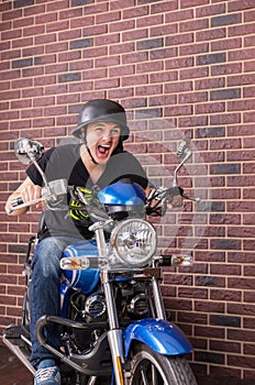Young man shouting as he speeds on his motorbike