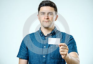 Young man showing blank business card or sign
