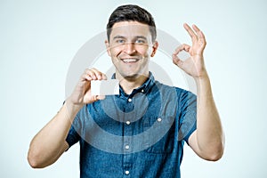 Young man showing blank business card or sign