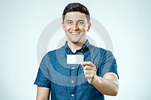 Young man showing blank business card or sign