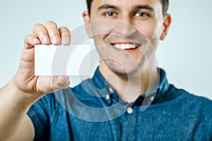 Young man showing blank business card or sign