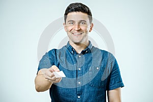 Young man showing blank business card or sign