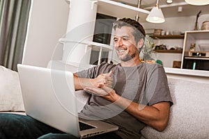 Man showing gesture in sign language, using laptop