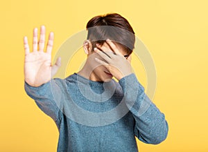 Young man showing his hand hiding  face