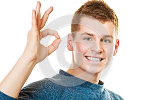 Young man showing ok hand sign gesture