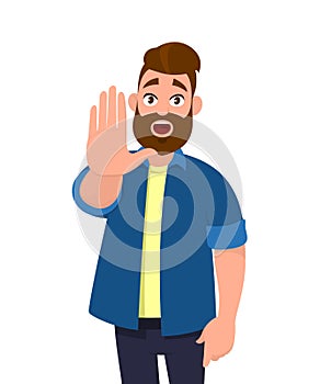 Young man showing palm as stop sign,stay, hold or rejection gesture.