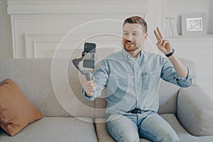 Young man showing peace gesture while video chatting