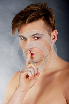 Young man showing silent gesture.