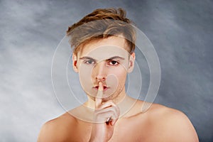 Young man showing silent gesture.
