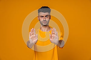 Young man showing stop sign with palms isolated