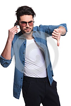 Young man showing the thumbs down gesture