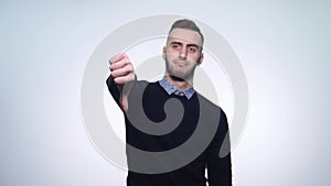 Young man showing thumbs down. Studio shot. White Background