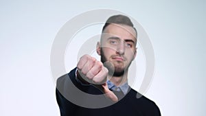 Young man showing thumbs down. Studio shot. White Background