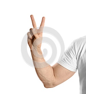 Young man showing victory gesture on white