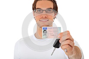 Young man shows his drivers license and car keys photo