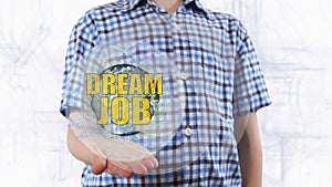 Young man shows a hologram of the planet Earth and text Dream job