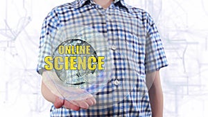 Young man shows a hologram of the planet Earth and text Online science