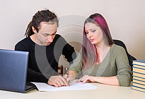 A young man shows on what the girl wrote on paper