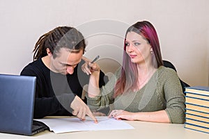 young man shows on written on paper, and a girl pokes a finger into his head