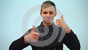 Young man sign success, making positive hand gesture, thumbs up. Portrait